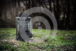 Broken stone cross, weathered gravestone on an old abandoned cemetery, concept for transience or gloomy halloween background with photo