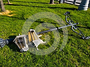 A broken street lamp lies on the grass. Street, park, spring, vandalism.