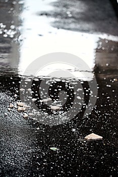 The broken tile. reflection in water. rain drops. Big rain pours on the street, pours sidewalks and nature. bulks on the water