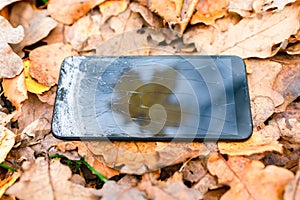 Broken touch phone on a background of autumn leaves .silhouette maple leaf, autumn concept