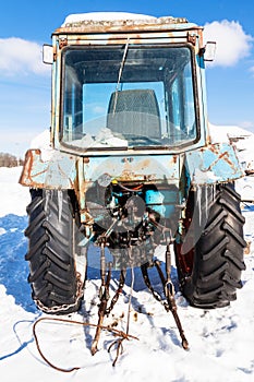 broken tractor on snowy road in sunny winter day