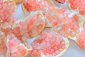 Broken-up pomegranate fruit on white background