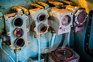 Broken and very old circular gauge and power switch with metal tube and electric wire inside the cockpit of abandoned n