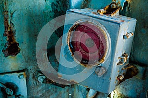 Broken and very old round gauge inside the cockpit of abandoned navy ship.