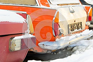 Broken vintage red rusty retro car parked in winter on snow background on frosty winter day