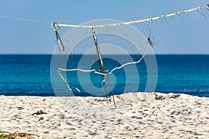 Broken volleyball net hanging on a beach