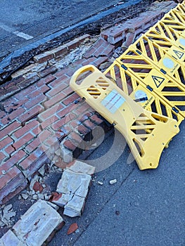 Broken Wall in A Carpark Been Hit by a Car With Warning Barrier Around the Fallen Bricks