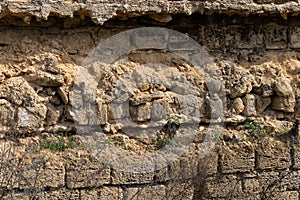 Broken wall of an old house nearby, traces of climate weathering. Cracked wall texture with hole. Brick stone wall of building