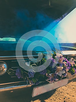 Broken wedding retro car, open hood and blue smoke coming from the engine.