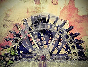 Broken wheel of an old abandoned water mill with vintage effect