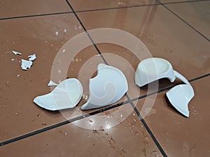 Broken white ceramic mug on floor closeup