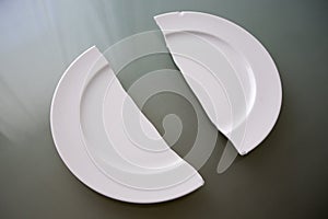 Broken white plate on glass table