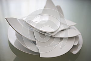 Broken white plates on glass table