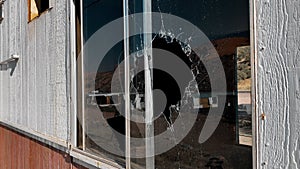 Broken window at an abandoned building, close up shot. Poverty and vandalism crime concept.