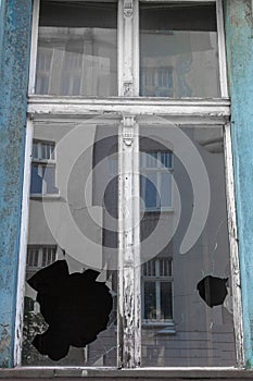 Broken window glass in abandoned old building. Dirty facade. Destruction concept. Vandalism concept. Grunge architecture exterior.