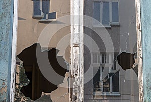 Broken window glass in abandoned old building. Dirty facade. Destruction concept. Vandalism concept. Grunge architecture exterior.