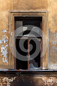 Broken window in an old abandoned house after a fire