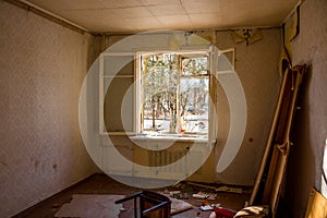 Broken window in a room of an abandoned house