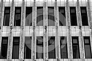 The broken windows in the abandoned building. Monochrome. Black-and-white.