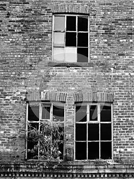 Broken windows in an abandoned derelict brick building