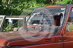 a broken windshield jeep parked in a residential yard