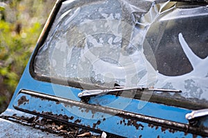 Broken windshield old blue abandoned car