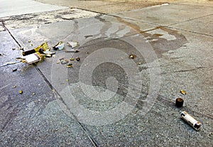 Broken wine bottle and lipstick on concrete pavement in the city