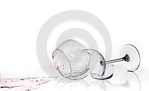 Broken wine glass on a quilted table on white background