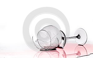 Broken wine glass on a quilted table on white background