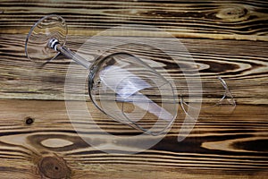 Broken wine glass with a shard on a  wooden background