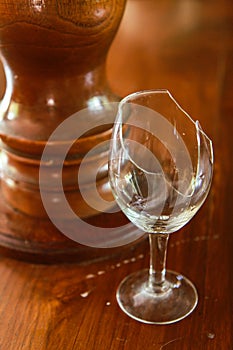 Broken wine glass on wooden bar counter