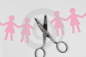 Broken women paper chain with scissors on white background - Bro