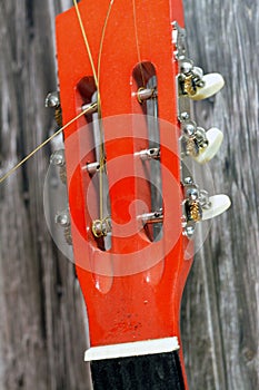 A broken wooden old classic guitar with damaged strings chords, shattered musical instrument, unattached damaged guitar with cut