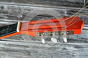 A broken wooden old classic guitar with damaged strings chords, shattered musical instrument, unattached damaged guitar with cut