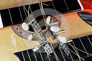 A broken wooden old classic guitar with damaged strings chords, shattered musical instrument, unattached damaged guitar with cut