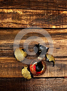 Broken Xmas ball with glass shards on wooden table