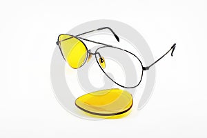 Broken yellow sunglasses lens on white background