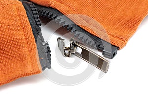 Broken zipper on orange shirt jacket. Detail close-up photo. Clothing repair concept