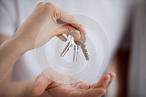 Broker hand holding keys giving to new home owner, closeup