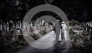 Brompton, London - Elderly couple walk away along graveyard path