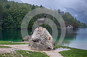 Bronse statue of legendary deer Zlatorog (The Golden Horn) under rain. Lake Bohinj. Slovenia