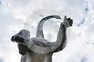 Brontosaurus seen from below with cloudy sky over it