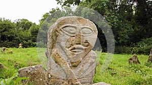 This is a bronze age stone carviing with two faces,called Janus, located In Caldragh Cemetery on Boa Island, Lower Lough