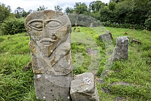 This is a bronze age stone carviing with two faces,called Janus, located In Caldragh Cemetery on Boa Island, Lower Lough