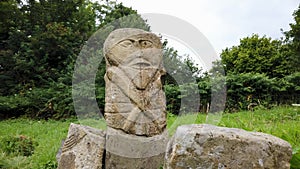 This is a bronze age stone carviing with two faces,called Janus, located In Caldragh Cemetery on Boa Island, Lower Lough