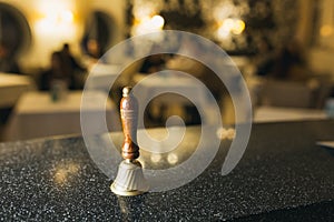 Bronze bell with wooden handle on table.