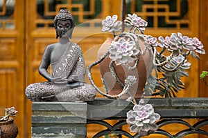 Bronze buddha statue against temple facade