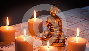 Bronze Buddha with warm lighted candles over limestone background