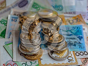 Bronze figures of a bull and a bear on the background of paper and metallic money. photo