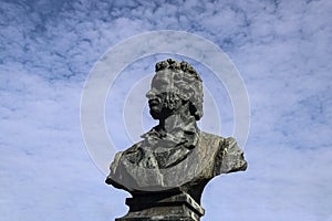 Bronze bust of Alexander Pushkin, on blue cloudy sky background. Monument of great russian poet in Batumi, Georgia